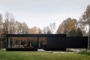 This all-black glass home was designed to wrap around an apple tree